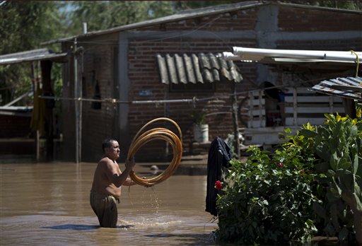 A man salvages items from his flooded front yard, two days after Hurricane Patricia, in the village of Rebalse, Jalisco State, Mexico, Sunday, Oct. 25, 2015. Patricia roared ashore in Mexico on Friday as a Category 5 terror that barreled toward land with winds up to 200 mph (320 kph). But the arrival of the most powerful hurricane on record in the Western Hemisphere caused remarkably little destruction. (AP Photo/Rebecca Blackwell)