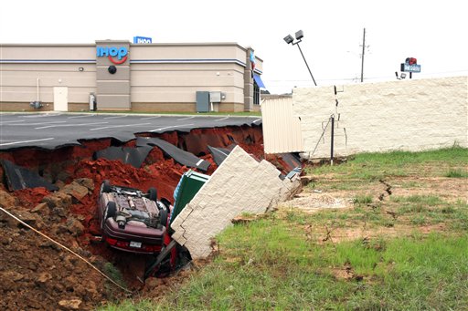 This photo shows vehicles after a cave-in of a parking lot in Meridian, Miss., Sunday, Nov. 8, 2015. Experts are to begin work Monday seeking to determine the cause of the Saturday collapse, authorities said. (Michael Stewart/The Meridian Star via AP) MANDATORY CREDIT