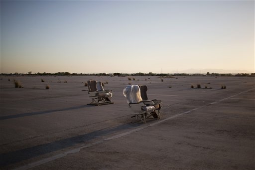 In this photo taken on Tuesday, May 19, 2015 scattered airliner seats lie on the tarmac of the abandoned former Athens International Airport, which shut down in 2001. The property, along with idling installations built for the Athens 2004 Olympics, is Greece's most valuable piece of real estate whose sale has been mired in controversy. (AP Photo/Petros Giannakouris)