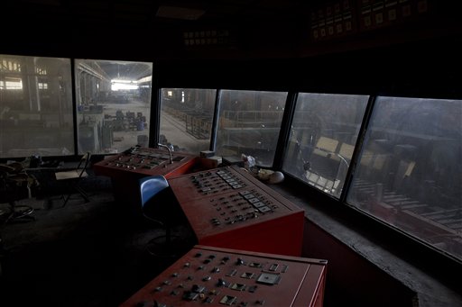 In this photo taken on Thursday, Nov. 26, 2015, machinery used to monitor production lies idle at the control room of an abandoned metal pipe-making factory. Hellenic Pipe Works was founded in 1967 and exported 80 percent of its production to the United States. In 1994 it was acquired by a construction group and was shut down in 2011. It still employs 30 people who show up once a week in shifts to prevent looting and claim they have not been paid in four years.