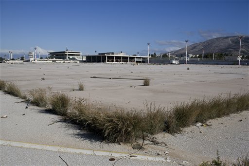 In this photo taken on Monday, Nov. 2, 2015, weeds have grown at the abandoned former Athens International Airport, which shut down in 2001. The property, along with idling installations built for the Athens 2004 Olympics, is Greece's most valuable piece of real estate whose sale has been mired in controversy. (AP Photo/Petros Giannakouris)