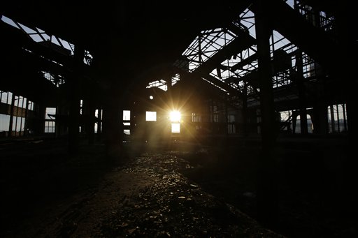 In this photo taken on Tuesday, May 19, 2015,  an abandoned fertilizer factory is lit by the sun near Athens' port city of Piraeus. The Chemical Products and Fertilizers Company, the owner, founded in 1910 and employing about 4,000 at its peak, was shut down in 1999. (AP Photo/Petros Giannakouris)