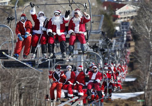 Skiers and snowboarders dressed as Santa ride a chairlift while participating in Santa Sunday at the Sunday River ski resort, Sunday, Dec. 6, 2015, in Newry, Maine. The resort hosted 150 Santas who raised $3,014 for the Sunday River Community Fund. (AP Photo/Robert F. Bukaty)