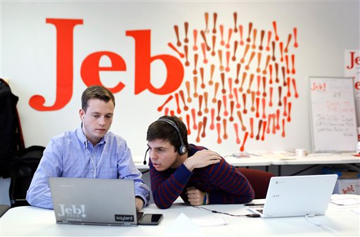 Campaign staffer Kyle Radon, left, and volunteer Jack Davidson look over information on a computer as they call Iowa residents from the state headquarters for Republican presidential candidate, former Florida Gov. Jeb Bush in West Des Moines, Iowa. (AP Photo/Patrick Semansky)