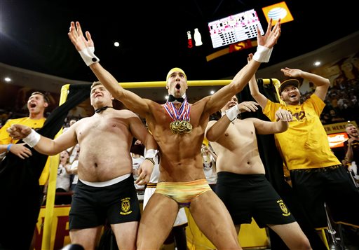 Olympic swimmer Michael Phelps, center, performs behind the "Curtain of Distraction" during an Oregon State free throw, Thursday, Jan. 28, 2016, in Tempe, Ariz. (AP Photo/Matt York)