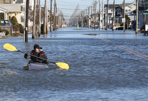 Max Sorensen of Stone Harbor, N.J., kayaks down Third Ave at 92nd Street in Stone Harbor, NJ, Sunday, Jan. 24, 2016. Clean-up efforts are underway in the wake of a winter storm that produced heavy snow amounts inland and record tidal flooding along the barrier Islands. (Dale Gerhard/Press of Atlantic City via AP)