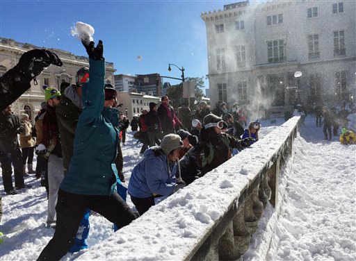 People participate in a snowball fight Sunday, Jan. 24, 2016, in Baltimore. Strict travel restrictions were lifted Sunday morning, as crews continued to work to clear snow from major streets and people enjoyed the sunny day. (AP Photo/Juliet Linderman)