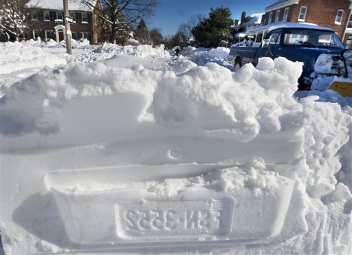 The imprint of a car license plate is left in the snow following the dig-out of vehicles in York, Pa., on Sunday, Jan 24, 2016. (York Daily Record via AP)