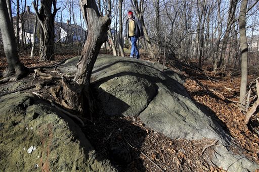 In this photo taken Jan. 11, 2016, Salem State University history professor Emerson Baker walks through an area that he and a team of researchers said is the exact site where 19 innocent people were hanged during the 1692 witch trials in Salem, Mass. Salem Mayor Kim Driscoll said the city plans to put a tasteful memorial at the site, which is known as Proctor's Ledge and is surrounded by private homes. (Ken Yuszkus/The Salem News via AP) MANDATORY CREDIT