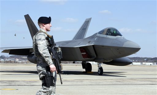 U.S. Air force military police stands guard near the one of four U.S. F-22 stealth fighters. (AP Photo/Lee Jin-man)