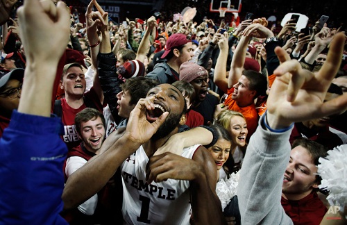 Temple's Josh Brown celebrates with students who stormed the court after Temple upset SMU, 89-80, in an NCAA college basketball game, Sunday, Jan. 24, 2016, in Philadelphia. (AP Photo/Matt Slocum)