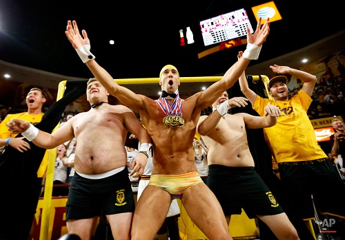 Olympic swimmer Michael Phelps, center, performs behind the "Curtain of Distraction" during an Oregon State free throw against Arizona State in the second half of an NCAA college basketball game, Thursday, Jan. 28, 2016, in Tempe, Ariz. (AP Photo/Matt York)