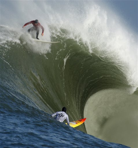 FILE - In this Feb. 13, 2010, file photo, Evan Slater, top, surfs a giant wave over Darryl "Flea" Virostko during the first heat of the Mavericks surf contest in Half Moon Bay, Calif. The world's best big-wave competition, Titans of Mavericks has been set for Friday, Feb. 12, 2016. Mavericks is the world's premiere, high adrenaline, big wave surfing event is a one-day invitation-only surfing competition that is held at the legendary Mavericks surf break located near Half Moon Bay, about 20 miles south of San Francisco. (AP Photo/Ben Margot, File)