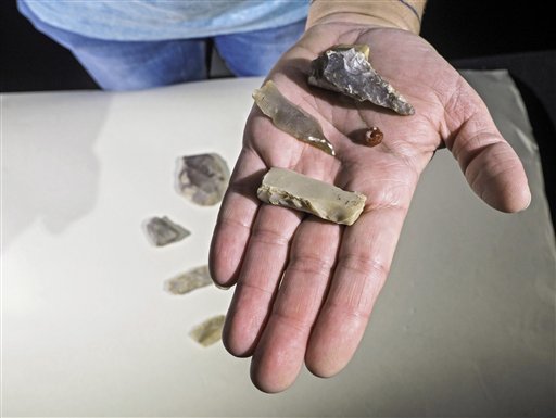 This handout photo released by the Israel Antiquities Authority on Wednesday, Feb. 15, 2016, shows polished flint axe and blades, and a gemstone bead found at a site of an ancient settlement in Jerusalem. Israeli archaeologists have discovered a 7,000-year-old settlement in northern Jerusalem in what they say is the oldest discovery of its kind in the area. (Assaf Peretz, Israel Antiquities Authority via AP)