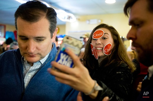 Delaney Anne tries to make a selfie with Republican presidential candidate, Sen. Ted Cruz, R-Texas, during a campaign stop, Monday, Jan. 18, 2016, in Tilton, N.H. (AP Photo/Matt Rourke)
