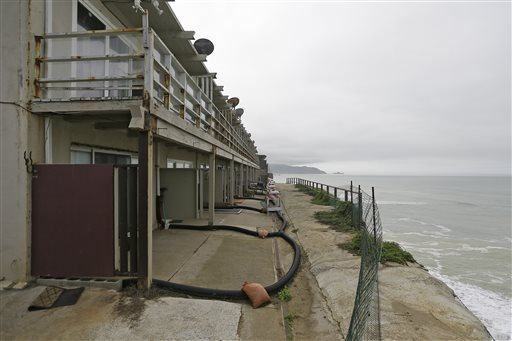 FILE - In this file photo from Monday, Jan. 25, 2016, an apartment complex stands on the edge of an eroding cliff Monday, Jan. 25, 2016, in Pacifica, Calif. Living with the Pacific Ocean as your backyard has its benefits. But the crumbling ocean cliffs have forced dozens to move quickly and at a high cost. Still, others remain, unsure of when the call to leave might come. The toll has been heavy in recent years. In 2010, two apartment buildings undermined by previous storms were evacuated and face demolition. Last month, during El Nino storms, the residents of another apartment building and two homes were forced to move out. Continuing erosion has left these three neighboring apartments sitting unsafely on the edge of an 80-foot bluff. (AP Photo/Eric Risberg)