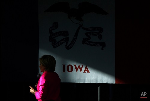 A patch of sunlight shines on the Iowa state flag as Democratic presidential candidate Hillary Clinton speaks during a town hall at Eagle Heights Elementary School in Clinton, Iowa, Saturday, Jan. 23, 2016. (AP Photo/Patrick Semansky)