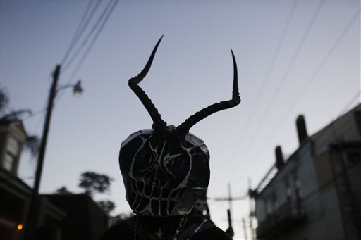 A member of the North Side Skull & Bone Gang parades down the streets during the wake up call for Mardi Gras, Tuesday, Feb. 9, 2016, in New Orleans. Their costumes are intended to represent the dead and they bring a serious message, reminding people of their mortality and the need to live a productive and good life. (AP Photo/Brynn Anderson)
