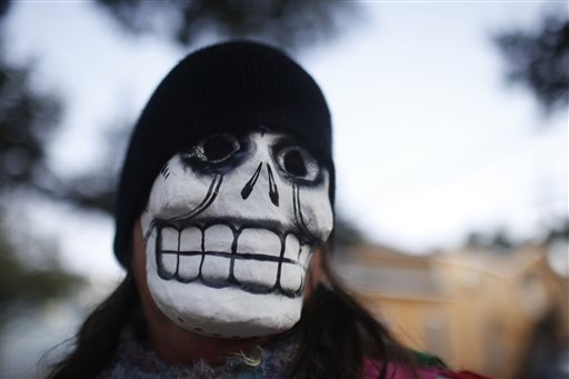 A parade-goer walks the streets with the North Side Skull & Bone Gang, during the wake up call for Mardi Gras, Tuesday, Feb. 9, 2016, in New Orleans. (AP Photo/Brynn Anderson)