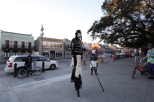 A member of the North Side Skull & Bone Gang dances in front of the Louis Armstrong park during the wake up call for Mardi Gras, Tuesday, Feb. 9, 2016, in New Orleans. Their costumes are intended to represent the dead and they bring a serious message, reminding people of their mortality and the need to live a productive and good life. (AP Photo/Brynn Anderson)
