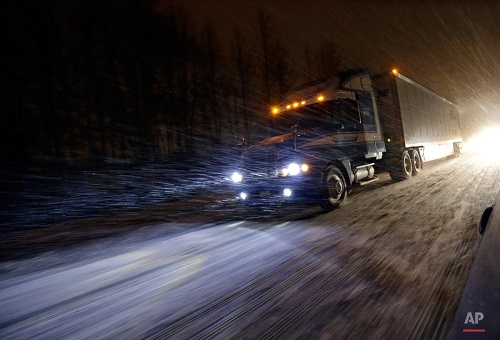 A tractor trailer rig drives during a snowstorm along the Atlantic City Expressway, Friday, Jan. 22, 2016, near Atlantic City. Most of the state was facing a blizzard warning from Friday evening until Sunday that called for up to 24 inches of snow, with the deepest accumulations in the central part of the state. (AP Photo/Mel Evans)