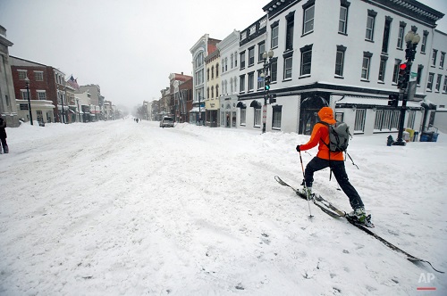 A man uses cross country skies as he goes down M Street NW in the snow, Saturday, Jan. 23, 2016 in the Georgetown area of Washington. A blizzard with hurricane-force winds brought much of the East Coast to a standstill Saturday, dumping as much as 3 feet of snow, stranding tens of thousands of travelers and shutting down the nation's capital and its largest city. (AP Photo/Alex Brandon)