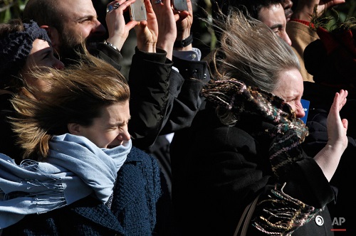 Women wave as their hair and scarves are blown in the wind from the Marine One helicopter as President Barack Obama leaves the South Lawn of the White House in Washington, Wednesday, Jan. 13, 2016, for a short trip to Andrews Air Force Base, Md., then onto Nebraska and Louisiana. (AP Photo/Jacquelyn Martin)