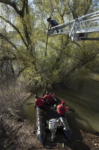 Sacramento Fire Department firefighters and Sacramento Animal Control officers rescue two cats from trees half-submerged due to the recent heavy rains in the Sacramento River near the Tower Bridge on Tuesday, March 15, 2016 in Sacramento, Calif.      (Randall Benton/The Sacramento Bee via AP)  MAGS OUT; LOCAL TELEVISION OUT (KCRA3, KXTV10, KOVR13, KUVS19, KMAZ31, KTXL40); MANDATORY CREDIT