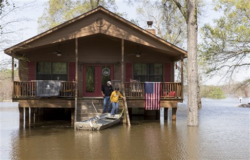 Residents make there way to a boat as water from Caddo Lake surrounds the raised house in Mooringsport, La., Sunday, March 13, 2016. President Barack Obama has signed an order declaring Louisiana's widespread flooding from heavy rains a major disaster. (Lee Celano/The Shreveport Times via AP) MAGS OUT; MANDATORY CREDIT SHREVEPORTTIMES.COM;  NO SALES
