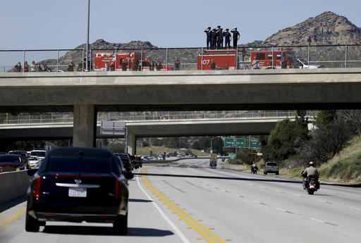 Firefighters salute as the hearse carrying the body of Nancy Reagan makes its way to the Ronald Reagan Presidential Library, Wednesday, March 9, 2016, near Porter Ranch, Calif. (AP Photo/Jae C. Hong, Pool)