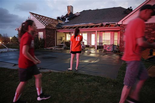 Sydney Ellis, center, looks at the damage to her family's home near Stone Canyon neighborhood after a tornado in Owasso, Okla., Wednesday, March 30, 2016. Multiple people were injured and authorities were evaluating the damage in northeastern Oklahoma after severe storms spawned multiple tornado touchdowns Wednesday night, authorities said. (Mike Simons/Tulsa World via AP) ONLINE OUT; KOTV OUT; KJRH OUT; KTUL OUT; KOKI OUT; KQCW OUT; KDOR OUT; TULSA OUT; TULSA ONLINE OUT; MANDATORY CREDIT