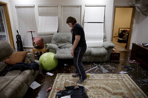 Kelli Ellis looks at the damage to her family's home near Stone Canyon neighborhood after a tornado in Owasso, Okla., Wednesday, March 30, 2016. Multiple people were injured and authorities were evaluating the damage in northeastern Oklahoma after severe storms spawned multiple tornado touchdowns Wednesday night, authorities said. (Mike Simons/Tulsa World via AP) ONLINE OUT; KOTV OUT; KJRH OUT; KTUL OUT; KOKI OUT; KQCW OUT; KDOR OUT; TULSA OUT; TULSA ONLINE OUT; MANDATORY CREDIT