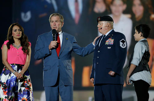 Former President George W. Bush, second from left, honors Air Force Master Sgt. Israel Del Toro, second from right, along with Del Toro's wife Carmen, left, and son Isreal Jr. during the opening ceremony for the Invictus Games, Sunday, May 8, 2016, in Kissimmee, Fla. Del Toro was injured while serving in Afghanistan. (AP Photo/John Raoux)