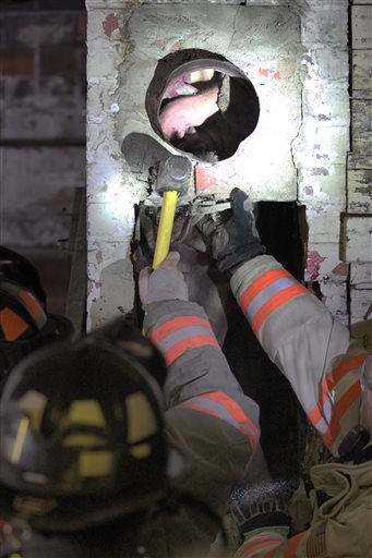 Carroll, Iowa, firefighters break apart a chimney to free a man who got stuck inside the night of May 17, 2016, apparently trying to break into Carroll Redemption Center, located in Carroll, Iowa. Jordan Kajewksi crawled into the chimney during the night of May 17, 2016, and was rescued the following day. He was naked and covered in soot, though he had his clothes with him. Kajewski was charged with trespassing. (Jared Strong/Carroll Daily Times Herald via AP)