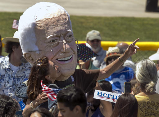 A supporter kisses a puppet of Democratic presidential candidate Sen. Bernie Sanders, I-Vt., during a campaign rally in Cathedral City, Calif., Wednesday, May 25, 2016. (AP Photo/Damian Dovarganes)