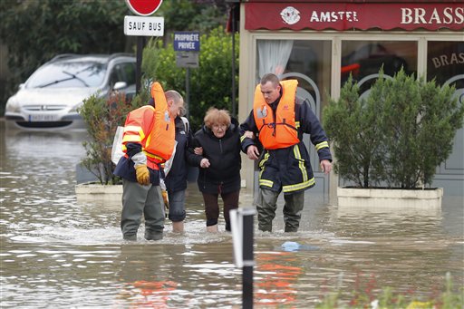 A woman is evacuated by rescuers in Longjumeau, south of Paris, Thursday, June 2, 2016. Floods inundating parts of France and Germany have left five people reported dead and thousands trapped in homes or cars, as rivers have broken their banks from Paris to Bavaria. (AP Photo/Francois Mori)