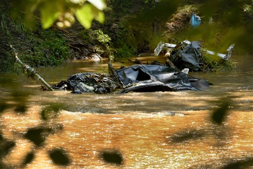 A submerged car is visible in the Patapsco River, seen from the Howard County side of Patapsco Valley State Park after the sidewalk caved in due to Saturday nights flooding in Ellicott City, Md., Sunday, July 31, 2016. Historic, low-lying Ellicott City, Maryland, was ravaged by floodwaters Saturday night, killing a few people and causing devastating damage to homes and businesses, officials said. (Amy Davis/The Baltimore Sun via AP)