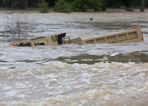 In this Sunday, Aug. 14, 2016 photo, a Louisiana Army National Guard dump truck that drove off the road is submerged in flood waters near Walker, La., after heavy rains inundated the region, (AP Photo/Max Becherer)