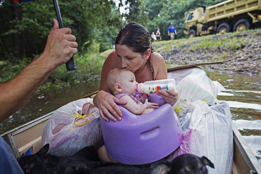 Danielle Blount kisses her 3-month-old baby Ember as she feeds her while they wait to be evacuated by members of the Louisiana Army National Guard near Walker, La., after heavy rains inundating the region, Sunday, Aug. 14, 2016. (AP Photo/Max Becherer)
