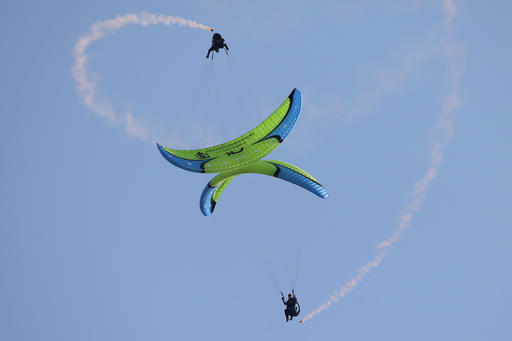 Paragliders perform synchronize aerobatic flight during the 43st Icare Cup paragliding festival in Saint Hilaire du Touvet, French Alps, Saturday, Sept. 24, 2016. The "Coupe Icare" dedicated to free flight, orchestrates all the various types of flying such as hang gliding, paragliding and acrobatic sailplaneing. (AP Photo/Francois Mori)