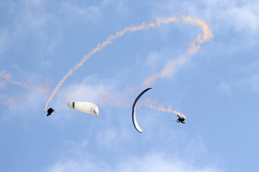 Paragliders perform synchronise aerobatic flight during the 43st Icare Cup paragliding festival in Saint Hilaire du Touvet, French Alps, Saturday, Sept. 24, 2016. The "Coupe Icare" dedicated to free flight, orchestrates all the various types of flying such as hang gliding, paragliding and acrobatic sailplaneing. (AP Photo/Francois Mori)