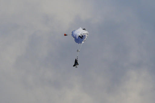 Swiss pilot Yves Rossy, known as 'Jetman,' the first man in the world to fly a jet-fitted wing, opens his parachute during a performance flight during the 43st Icare Cup paragliding festival in Saint Hilaire du Touvet, French Alps, Saturday, Sept. 24, 2016. The "Coupe Icare" dedicated to free flight, orchestrates all the various types of flying such as hang gliding, paragliding and acrobatic sailplaneing. (AP Photo/Francois Mori)