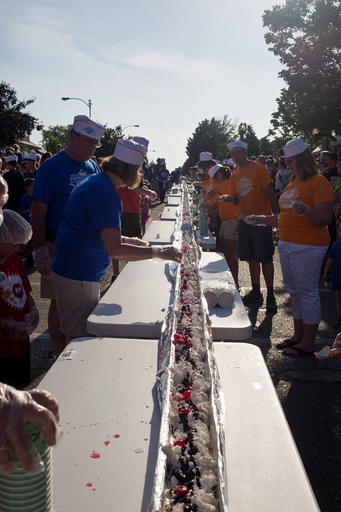 FILE - In this June 11, 2016 file photo, an ice cream sundae is completed during the world record attempt for the longest ice cream dessert along eight city blocks in Ludington, Mich. House of Flavors, one of Michigan's original, continuously-operating ice cream makers and parlors put on the event. Guinness World Records informed Ludington this week that the ice cream shop now holds the record after the June event. Officials say the sundae measured a bit over 2,970 feet in length. According to Guinness, the previous record for the longest ice-cream dessert of 1,957 feet and 1 inch was set in 2015 in Manurewa, New Zealand. (Erin Lefèvre/Muskegon Chronicle-MLive.com via AP, File)