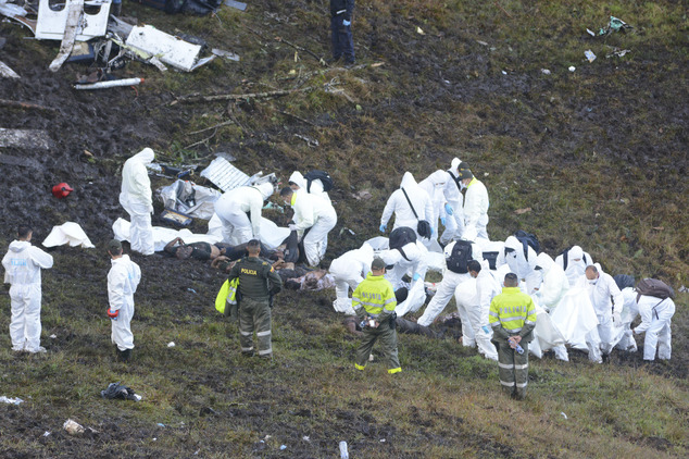 Rescue workers arrange the bodies of victims of an airplane that crashed in La Union, a mountainous area outside Medellin, Colombia, Tuesday , Nov. 29, 2016. The plane was carrying the Brazilian first division soccer club Chapecoense team that was on it's way for a Copa Sudamericana final match against Colombia's Atletico Nacional. (AP Photo/Luis Benavides)