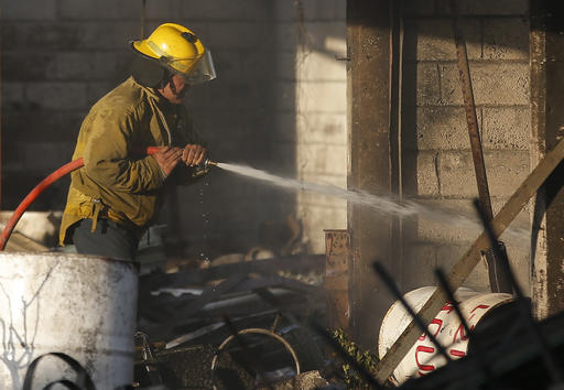 A fireman sprays water at the open-air San Pablito fireworks market, in Tultepec, outskirts of Mexico City, Mexico, Tuesday, Dec. 20, 2016.  An explosion ripped through Mexico’s best-known fireworks market where most of the fireworks stalls were completely leveled. According to the Mexico state prosecutor there are dozens dead. (AP Photo/Eduardo Verdugo)