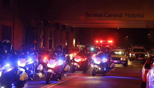 Motorcycle law enforcement officers lead a procession away from Tacoma General Hospital of an ambulance bearing the body of a Tacoma Police officer who was shot and killed while answering a domestic violence call Wednesday, Nov. 30, 2016, in Tacoma, Wash. Tacoma Police spokeswoman Loretta Cool said the officer was pronounced dead at the hospital Wednesday evening. "We've suffered a great loss and I think the community has suffered a great loss. I don't know how to put that into words," Cool said. (AP Photo/Ted S. Warren)