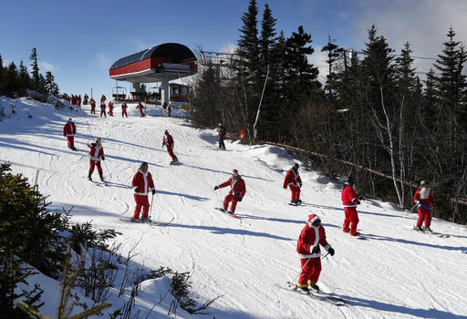 Skiers dressed as Santa Claus ski en masse, Sunday, Dec. 4, 2016, at the Sunday River ski resort in Newry, Maine. The annual Santa Sunday event raises money for local charities. (AP Photo/Robert F. Bukaty)